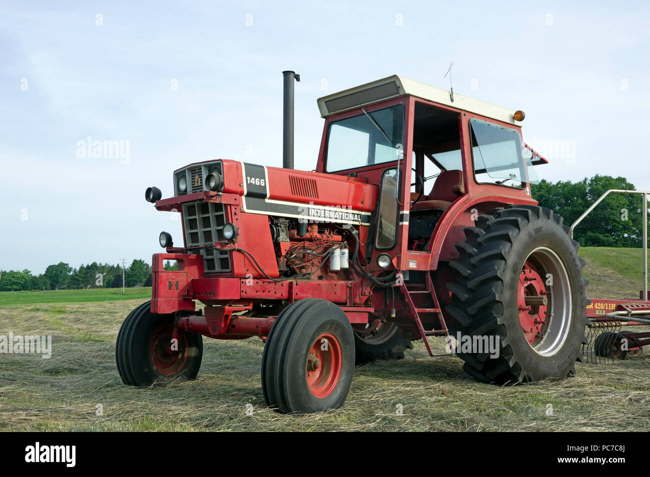 International Harvester modello diesel 1466 Trattore per filari in campo di fieno Foto Stock