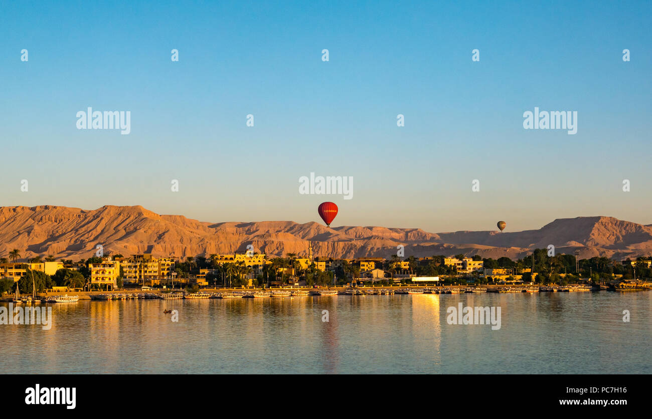 Vista sul Fiume Nilo verso il West Bank e la Valle dei Re con i palloni ad aria calda in aumento in mattina presto, Luxor, Egitto, Africa Foto Stock
