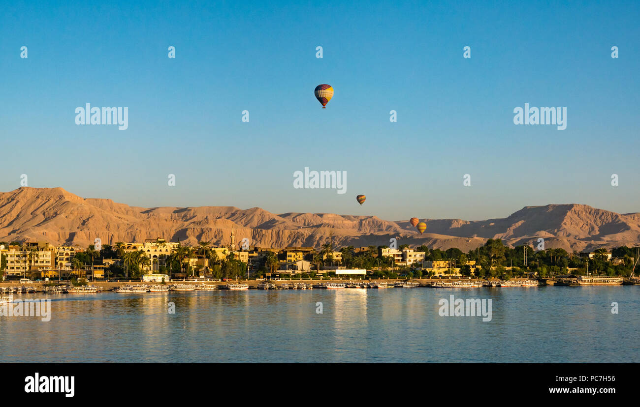 Vista sul Fiume Nilo verso il West Bank e la Valle dei Re con i palloni ad aria calda in aumento in mattina presto, Luxor, Egitto, Africa Foto Stock