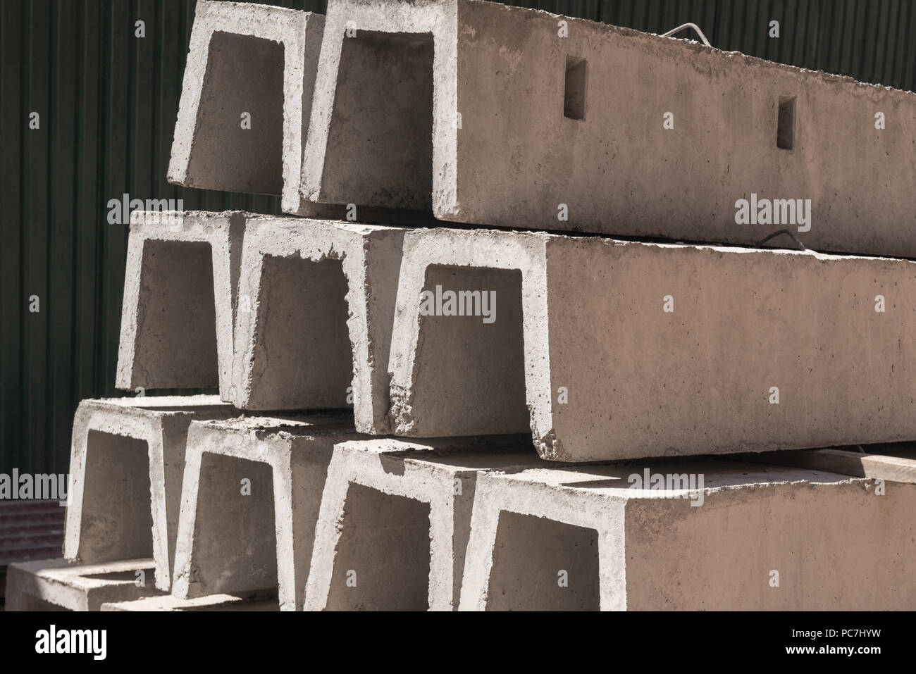 Nuovi blocchi in calcestruzzo per il drenaggio, impilati in una fila. materiale da costruzione Foto Stock