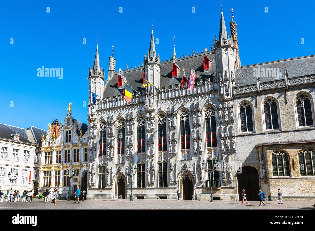 Piazza Burg e la città o il municipio, Stadhuis city hall, Stadsbestuur Bruge, con turisti sito vedendo, Bruges, Belgio Foto Stock