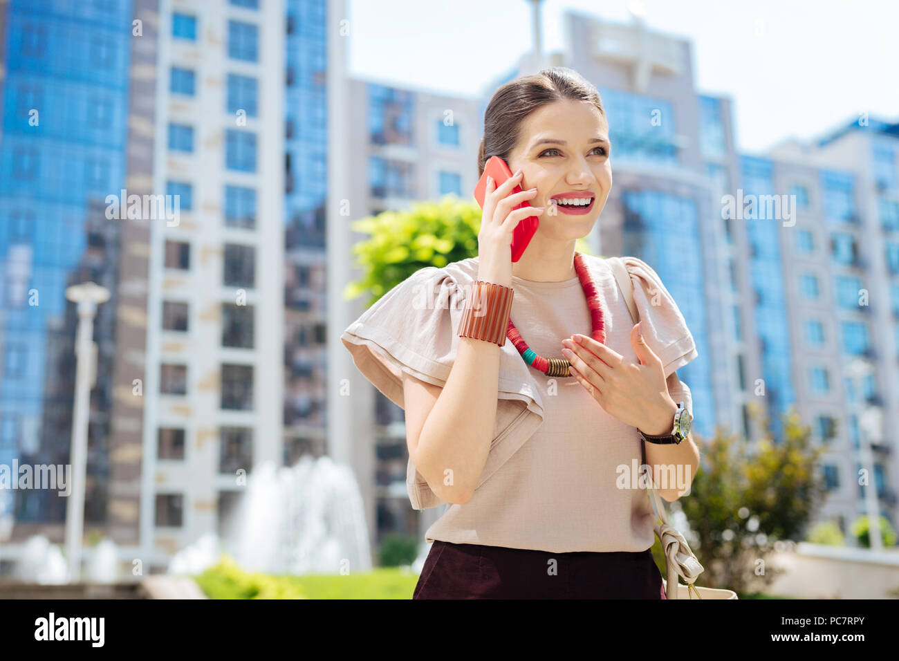 Positivo bella donna godendo della sua conversazione Foto Stock