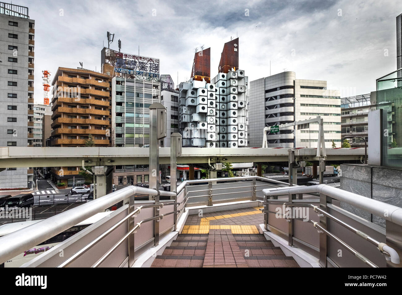 Nakagin Capsule Tower e calcestruzzo edifici appartamento dietro elevato bridge road della Shuto Expressway in Shimbashi, Tokyo, Giappone. La Nakagin Capsule Foto Stock