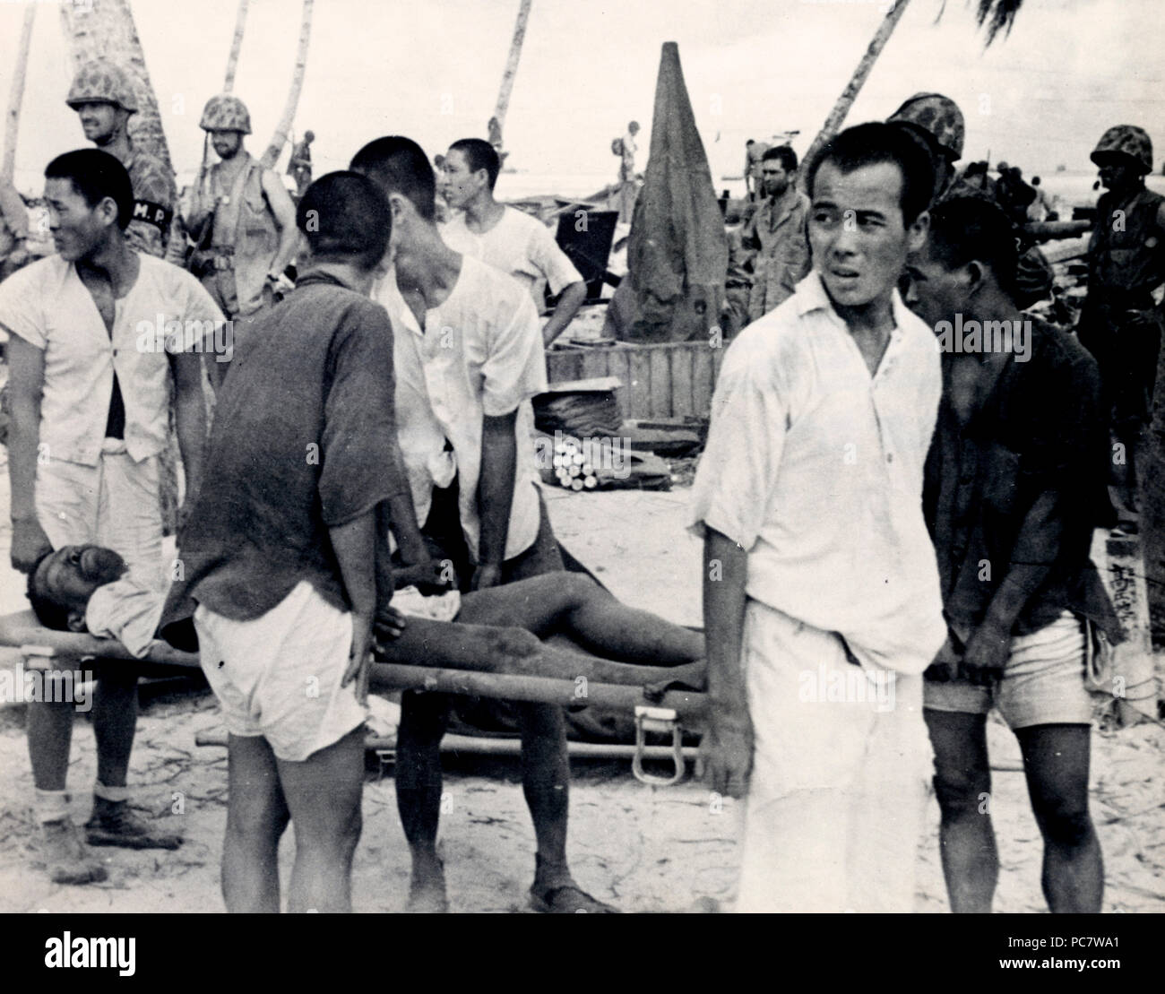 Operai coreani utilizzato dai giapponesi a costruire le difese di isola di trasportare un ferito il compagno per ricevere il trattamento - a Tarawa Foto Stock
