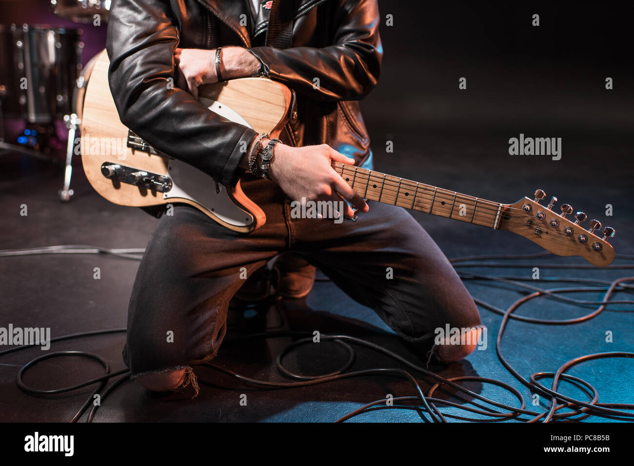 Chitarrista elettrico maschio nero seduto sullo sgabello che suona Keeley  Pedali di chitarra al Musical Instrument Convention Foto stock - Alamy