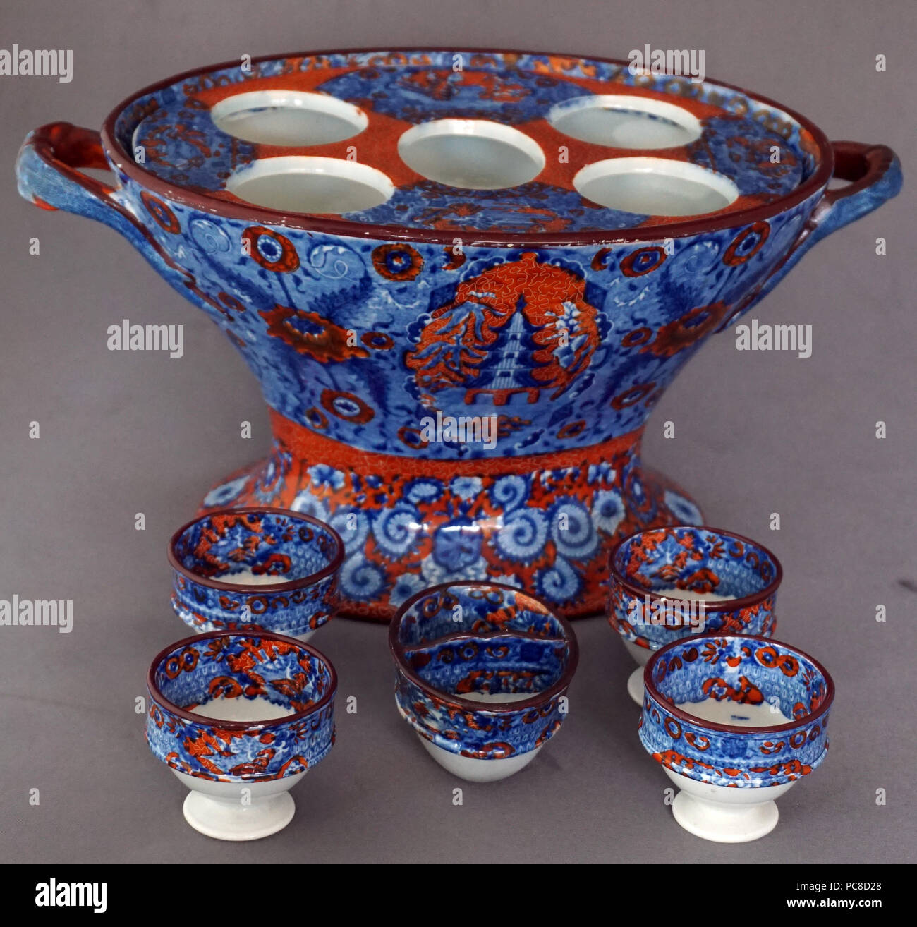 Antichi porcellana inglese Royal Worcester ampolla di uovo uovo Cup Stand titolare Chinoiserie un brano Pattern in blu e rosso Foto Stock