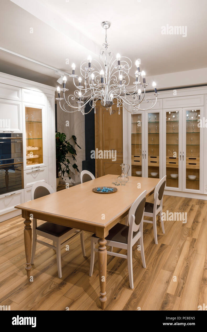 Cucina elegante con un elegante tavolo in legno e un lampadario Foto stock  - Alamy