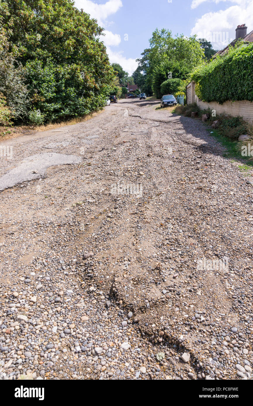 I solchi sviluppato su un unadopted strada di ghiaia a Bromley, a sud di Londra, dopo forti piogge a seguito di un lungo periodo secco nell'estate del 2018. Foto Stock
