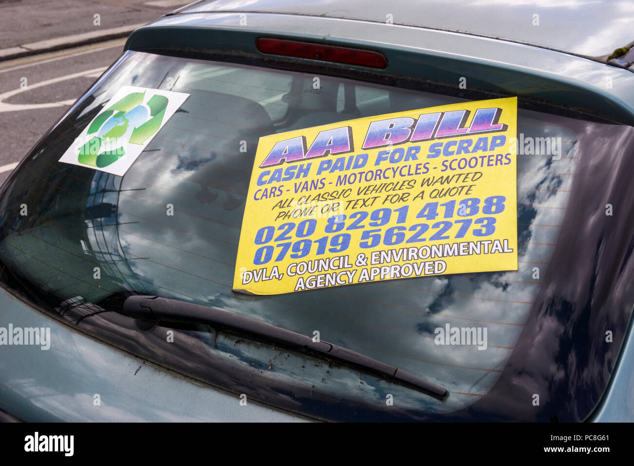 Un segno in una finestra di auto a sud di Londra offre la possibilità di pagare in contanti per la rottamazione delle auto, furgoni, motocicli e scooter. Foto Stock