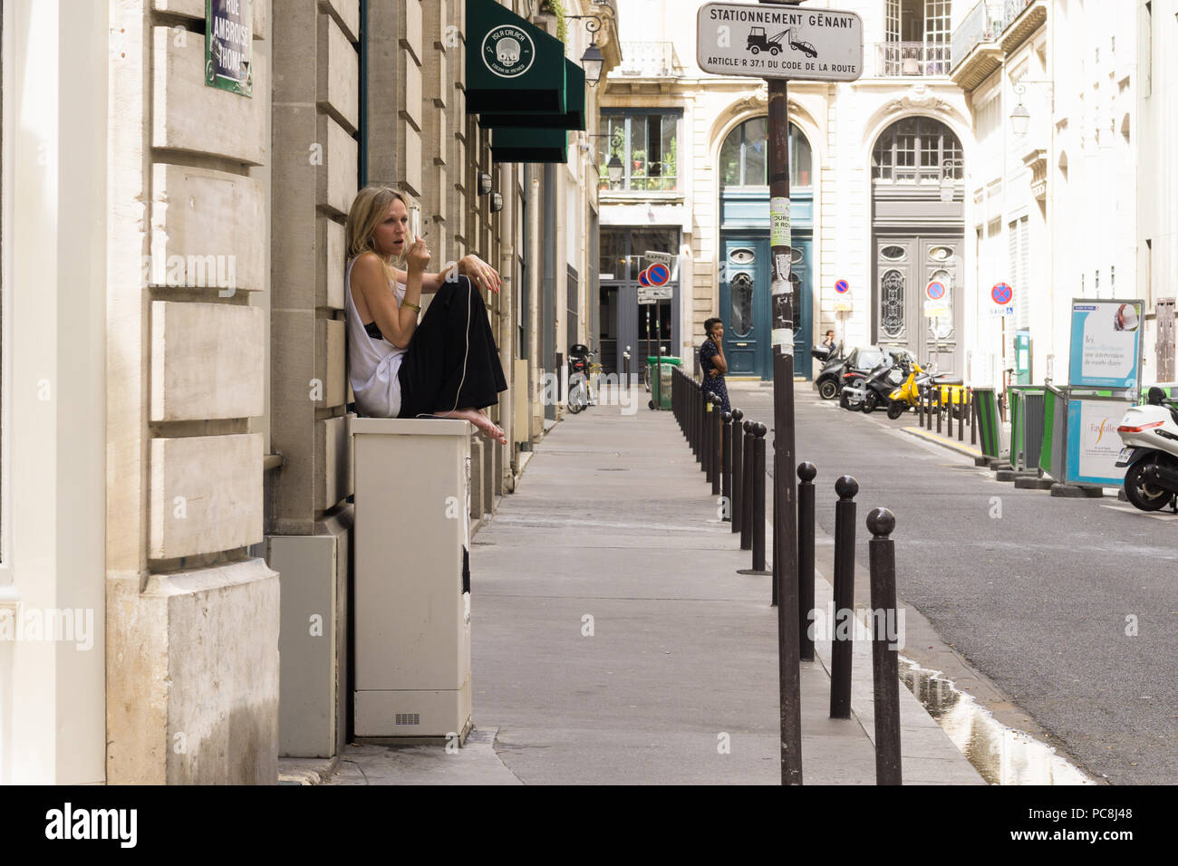 Parigi donna scena di strada - a piedi nudi rilassato donna parigina parlando al telefono in strada, la Francia, l'Europa. Foto Stock