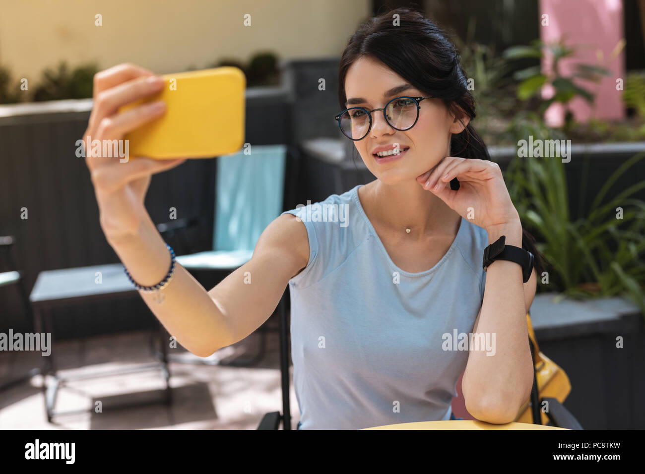 Pendente in argento. Elegante donna che indossa nizza pendente argento sorridere mentre facendo foto con il suo telefono Foto Stock