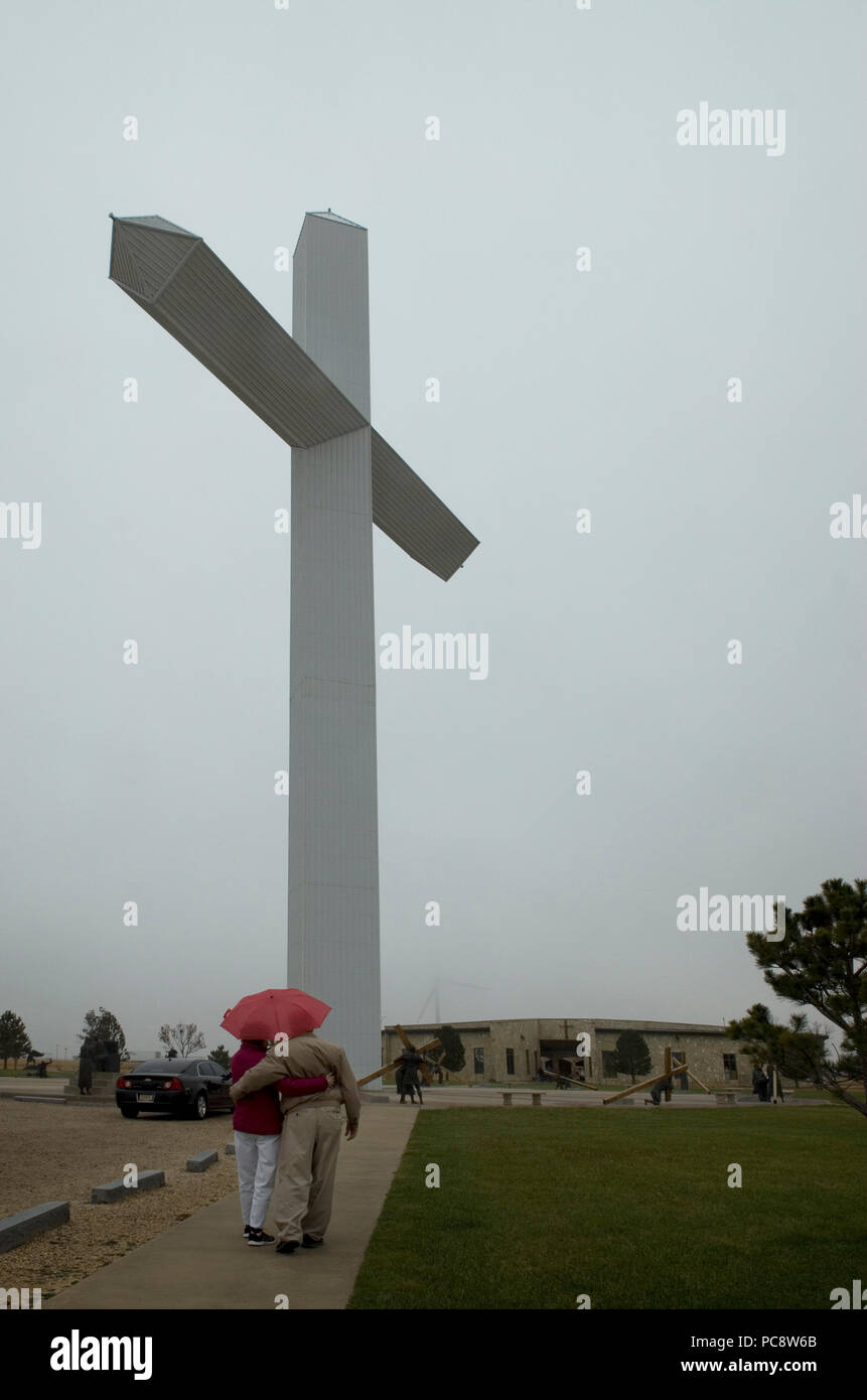 Coppia senior weathers la pioggia per visualizzare la gigantesca croce a Sposo, Texas USA Foto Stock