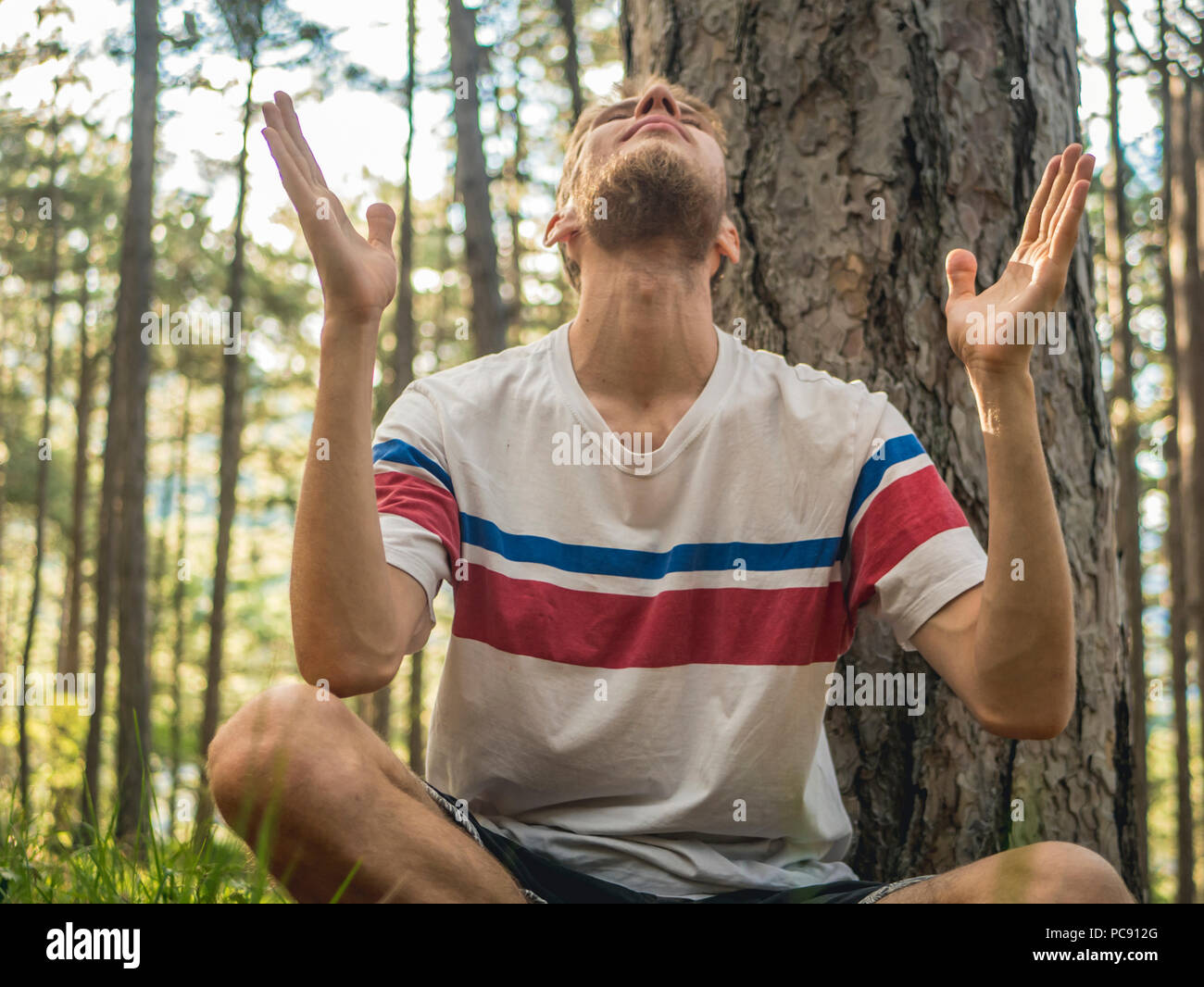 Close up ritratto dell'uomo facendo yoga e attività spirituale nella foresta di natura Foto Stock