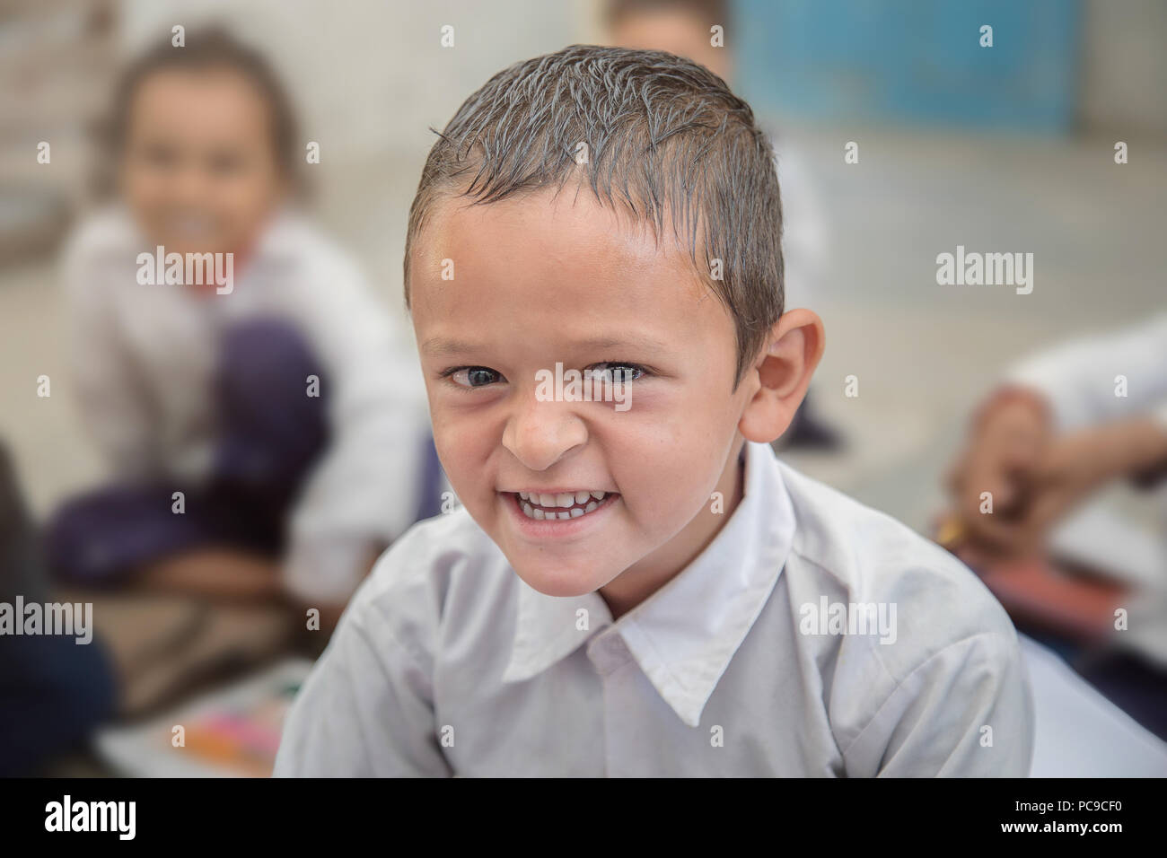 Sorridente/indiano Asian Village Scuola ritratto ragazzo seduto nella sua classe. Foto Stock