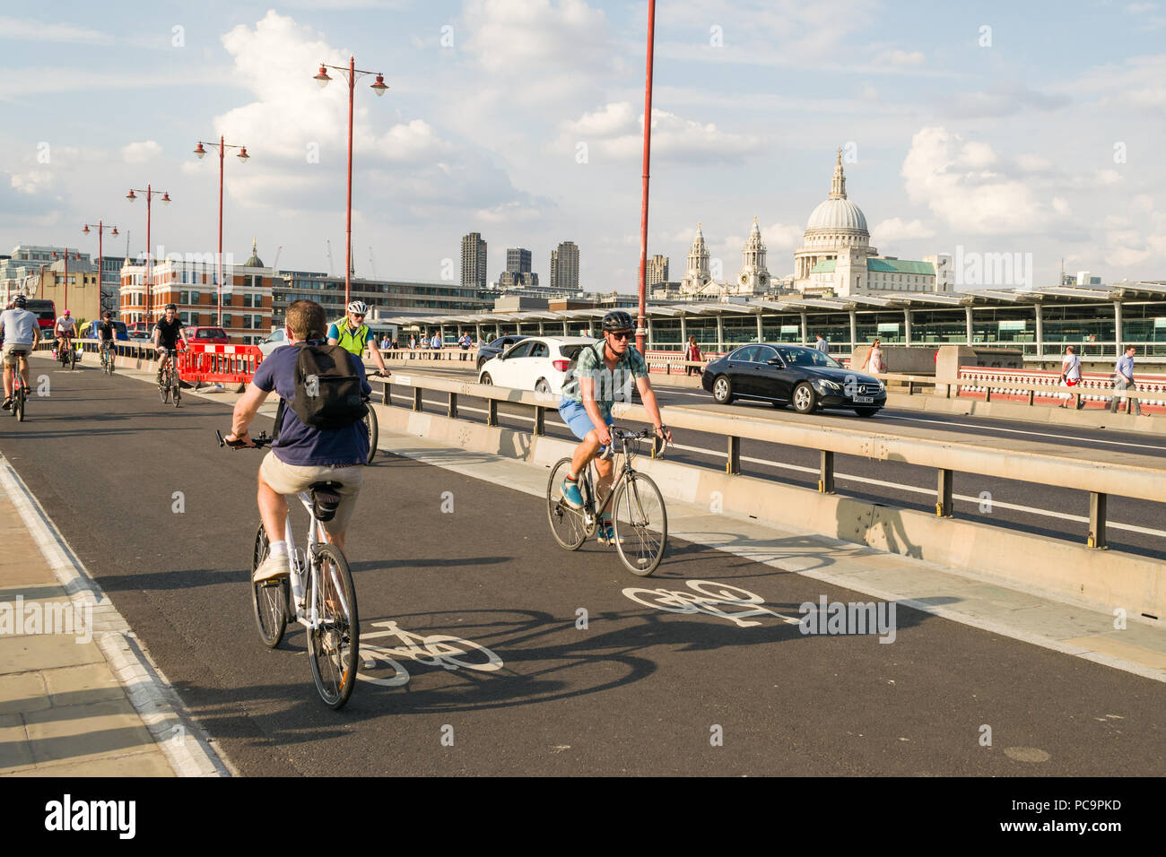 I ciclisti il pendolarismo su CS6 superhighway ciclo su Blackfriars Bridge in ora di punta con la Cattedrale di Saint Paul in background, London, Regno Unito Foto Stock