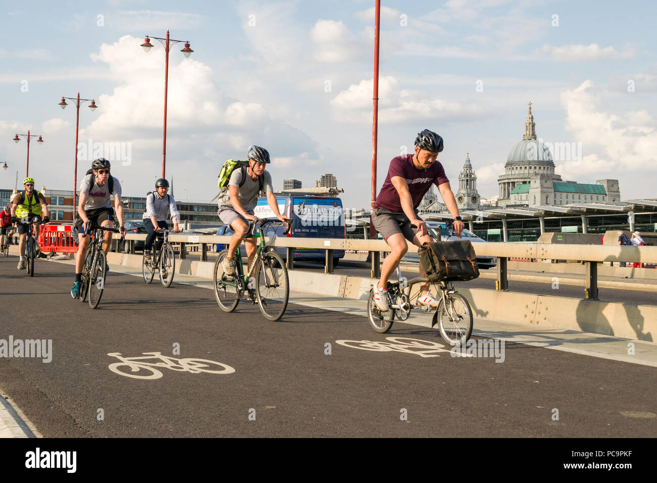 I ciclisti il pendolarismo su CS6 superhighway ciclo su Blackfriars Bridge in ora di punta con la Cattedrale di Saint Paul in background, London, Regno Unito Foto Stock