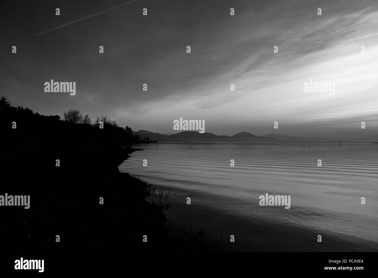 Bellissima vista del lago Trasimeno (Umbria, Italia), con colline e cielo riflettendo sull'acqua Foto Stock