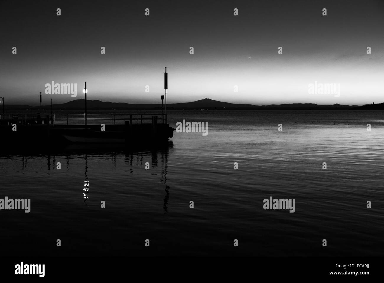 Un molo presso il lago Trasimeno (Umbria, Italia) al tramonto Foto Stock