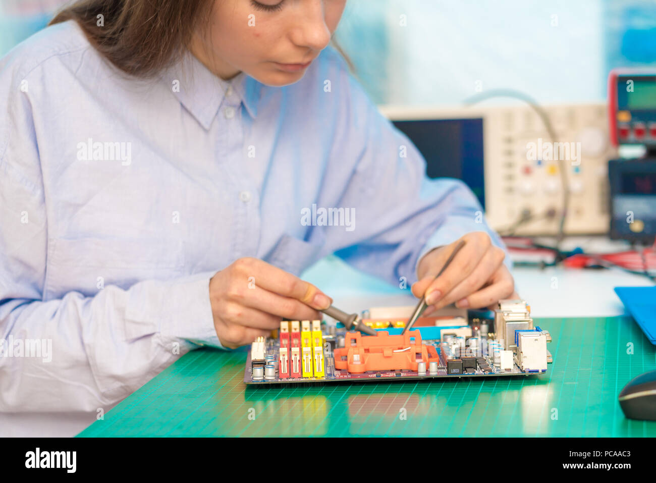 Studentessa in elettronica classe utilizza un dispositivo di misurazione Foto Stock