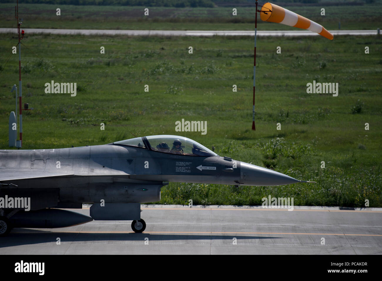 Un rumeno pilota dell'aeronautica si prepara a prendere il via in un F-16 Fighting Falcon su Borcea Air Base, Romania, 26 luglio 2018. Il Romanian Air Force ha ottenuto la F-16s in 2016. Stati Uniti Air Force Il personale di manutenzione ha visitato Borcea per fornire aiuto visivo e condividere la manutenzione dei velivoli i processi con i rumeni come parte di tre settimane di impegno. (U.S. Air Force foto di Senior Airman Devin Boyer) Foto Stock