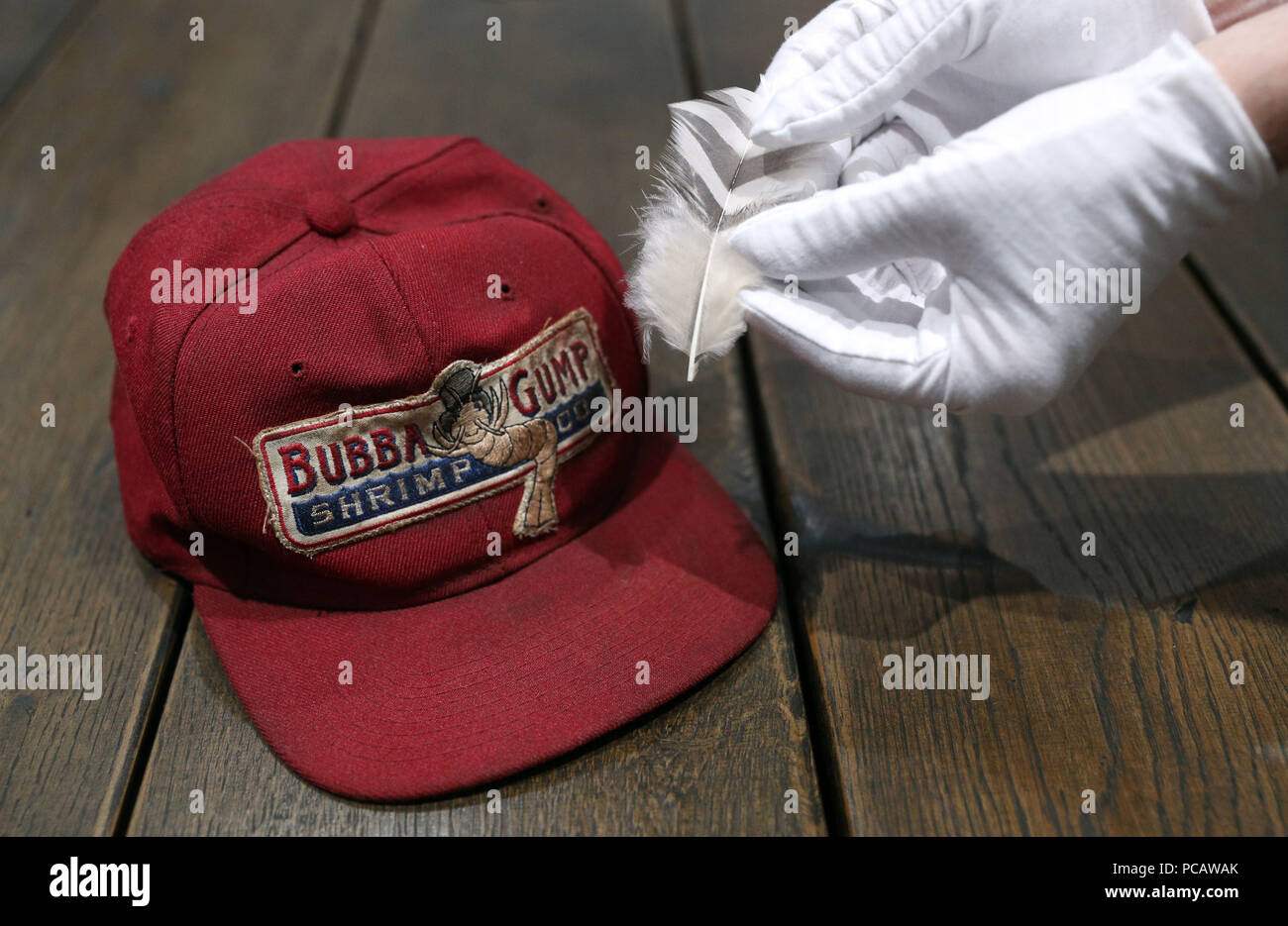 Un puntello dipendente del negozio trattiene una piuma dal film Forrest Gump  (stima (&pound;5-7000) al fianco di un Bubba Gump cappello indossato da Tom  Hanks (stima &pound;5-7000) nel puntello Store sede vicino