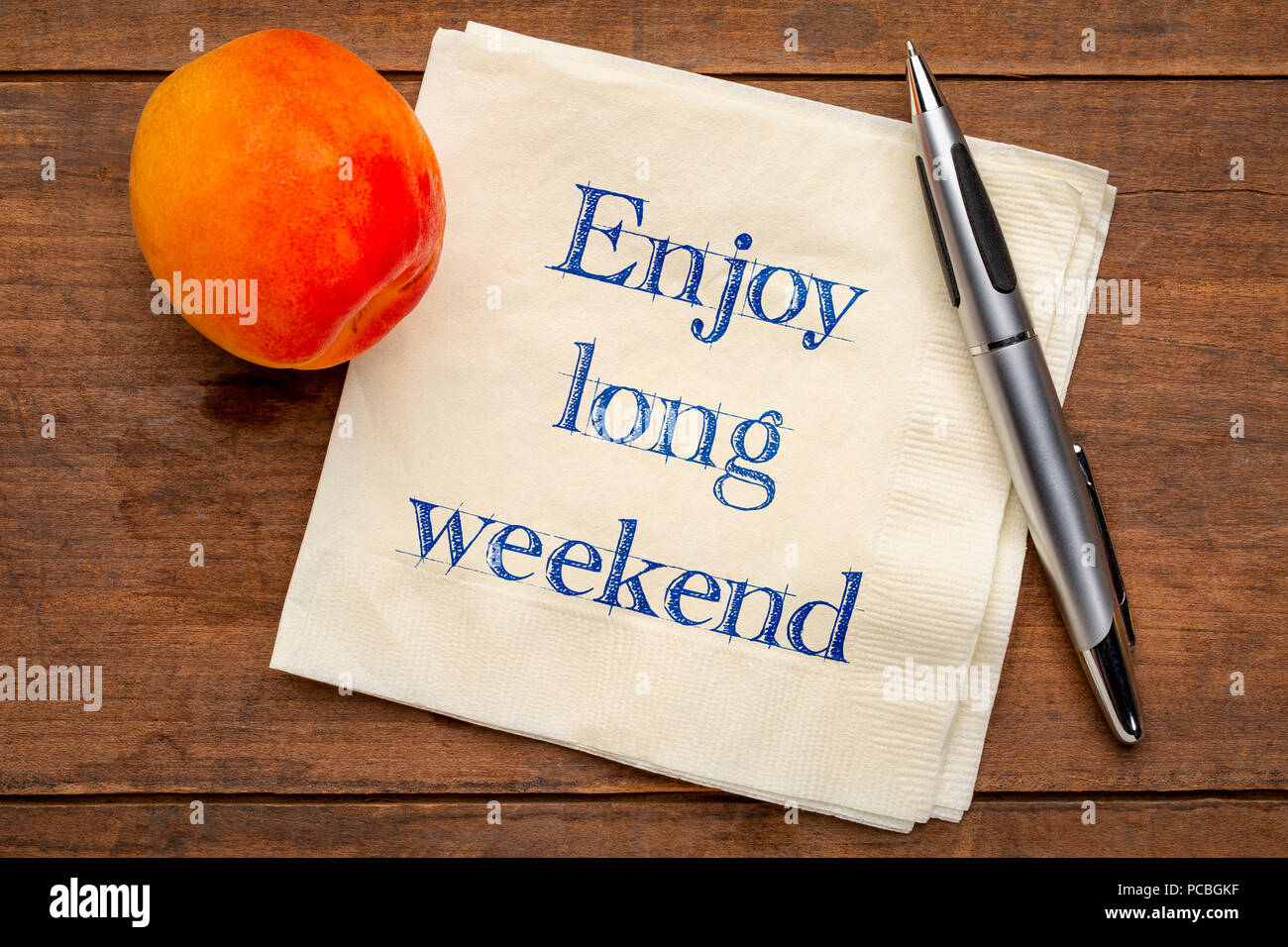 Godetevi un lungo weekend - scrittura su un tovagliolo con un albicocca fresca Foto Stock