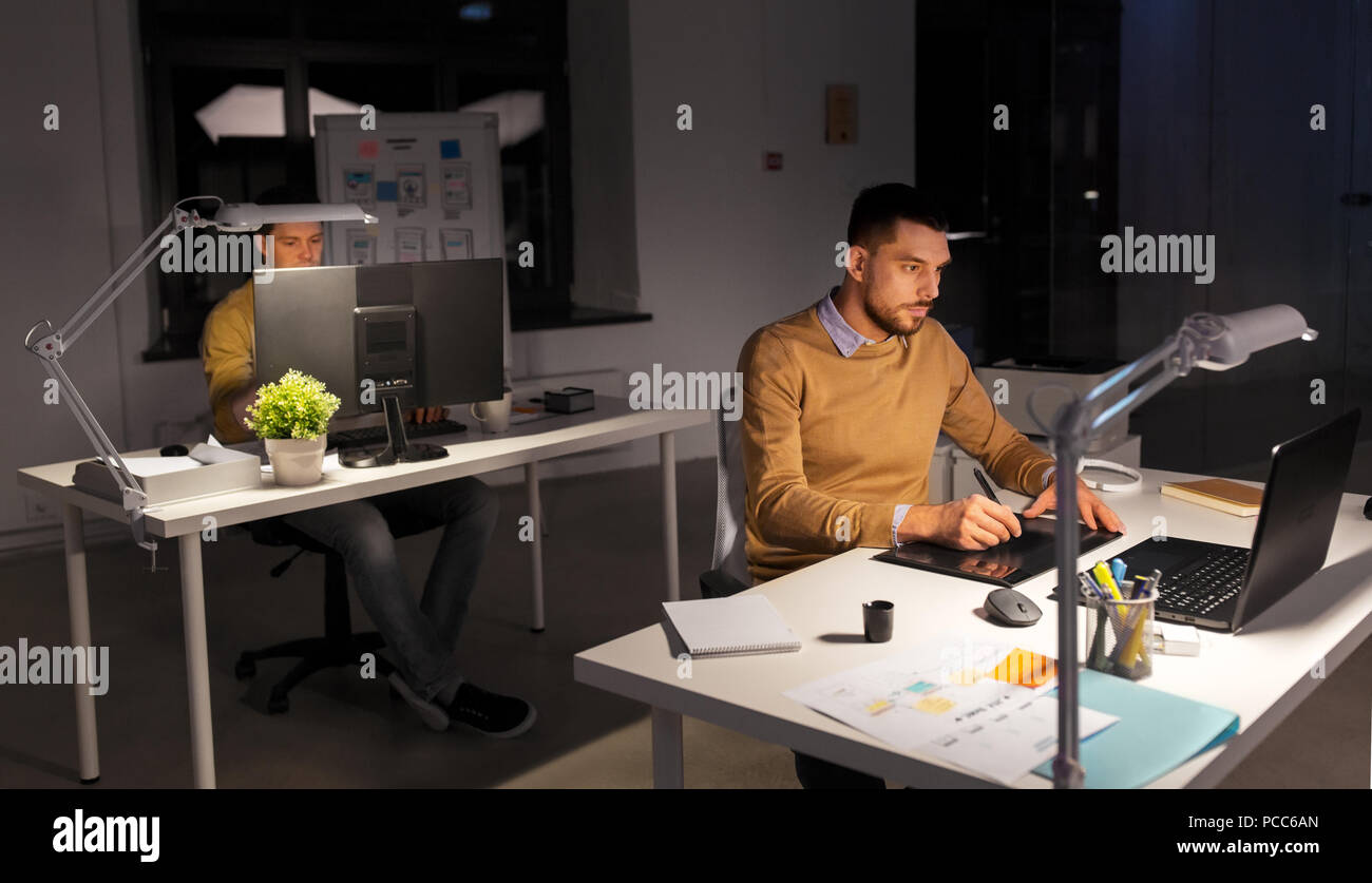 Uomo o designer con computer e tablet in ufficio Foto Stock