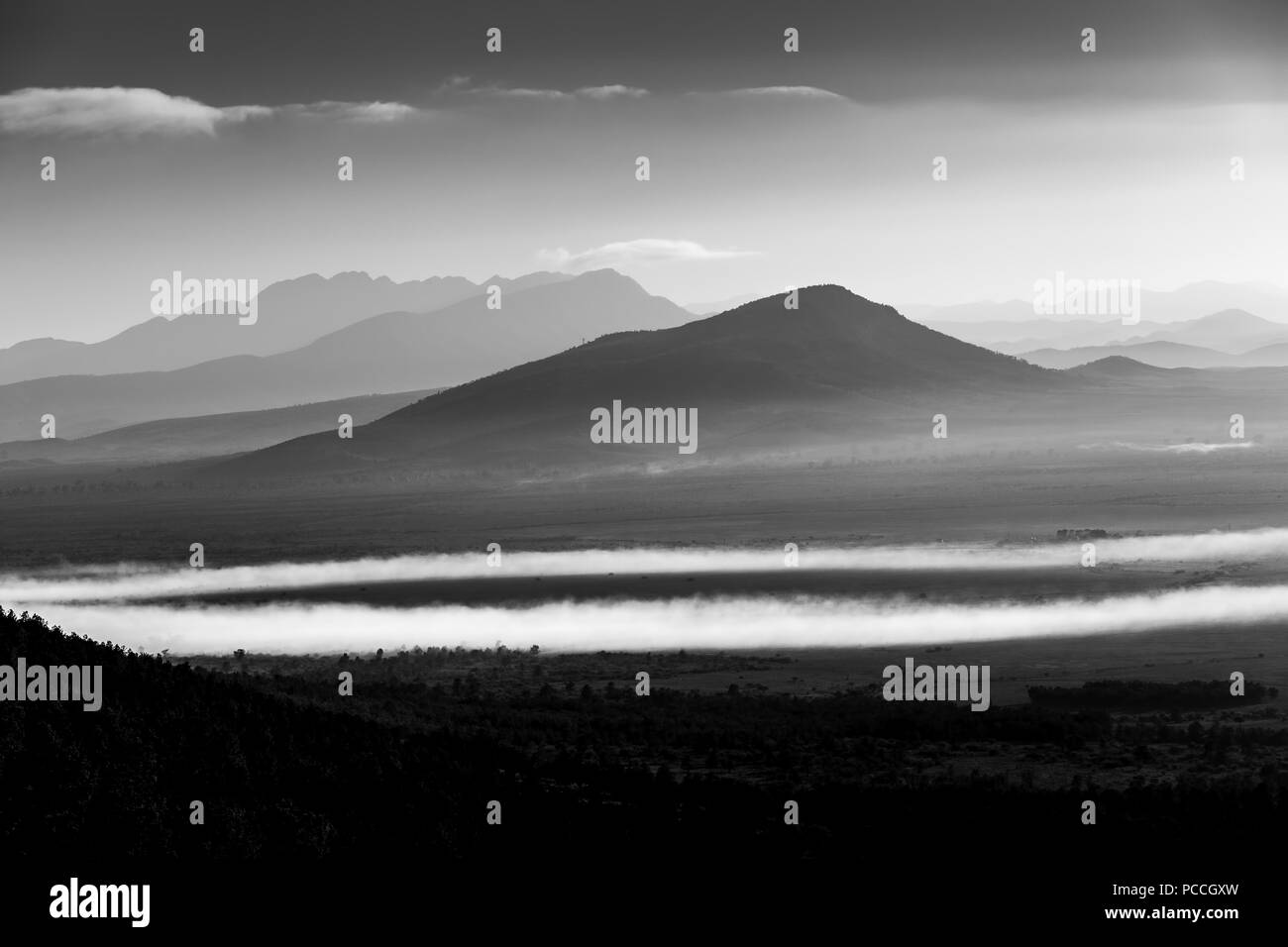 Le cime frastagliate e basse nubi patch a sunrise - bianco e nero paesaggio Foto Stock