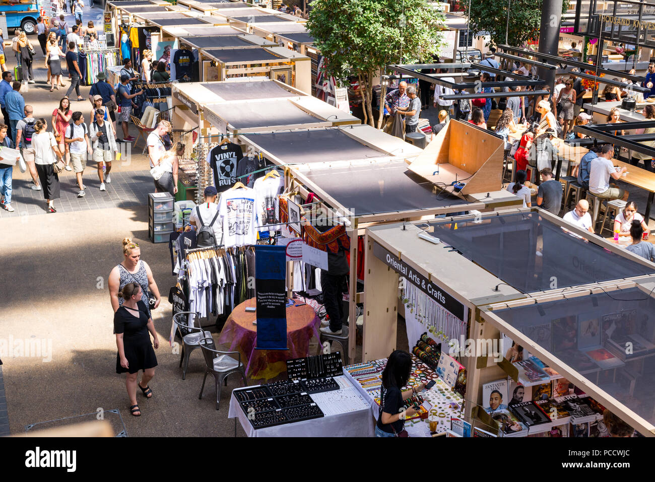 People Shopping e passeggiando per le bancarelle in Old Spitalfields mercato coperto. Spitalfields, East London, Regno Unito Foto Stock