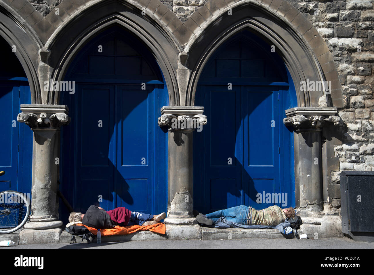 Londra. Hackney. Shoreditch. Due uomini senzatetto dormire in una porta. Foto Stock