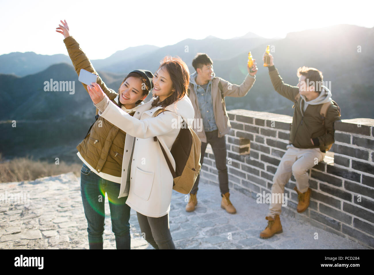 Felice giovani amici cinesi divertirsi sulla Grande Muraglia Foto Stock