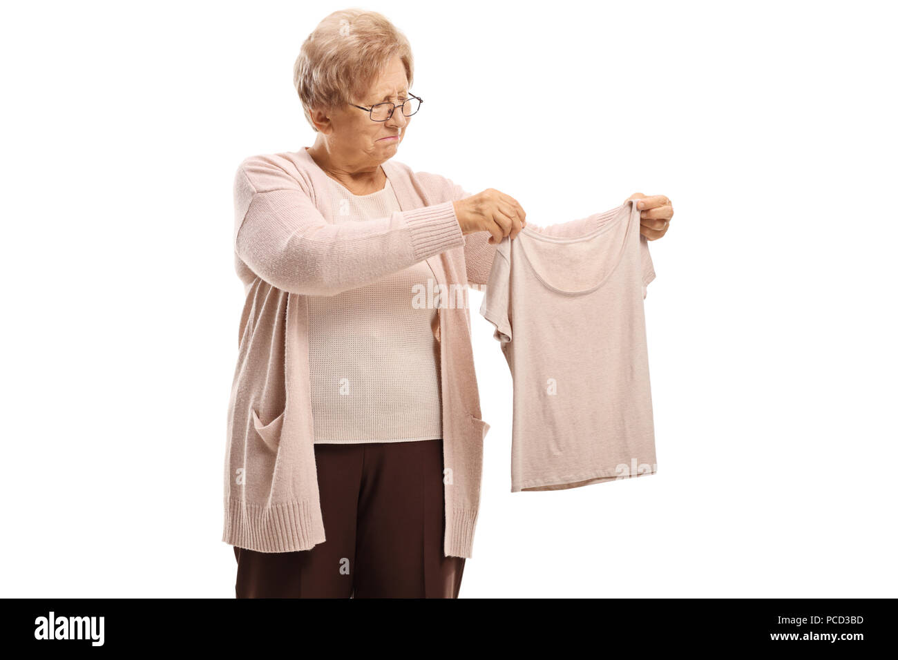 Deluso donna anziana guardando un shrunken camicetta isolati su sfondo bianco Foto Stock