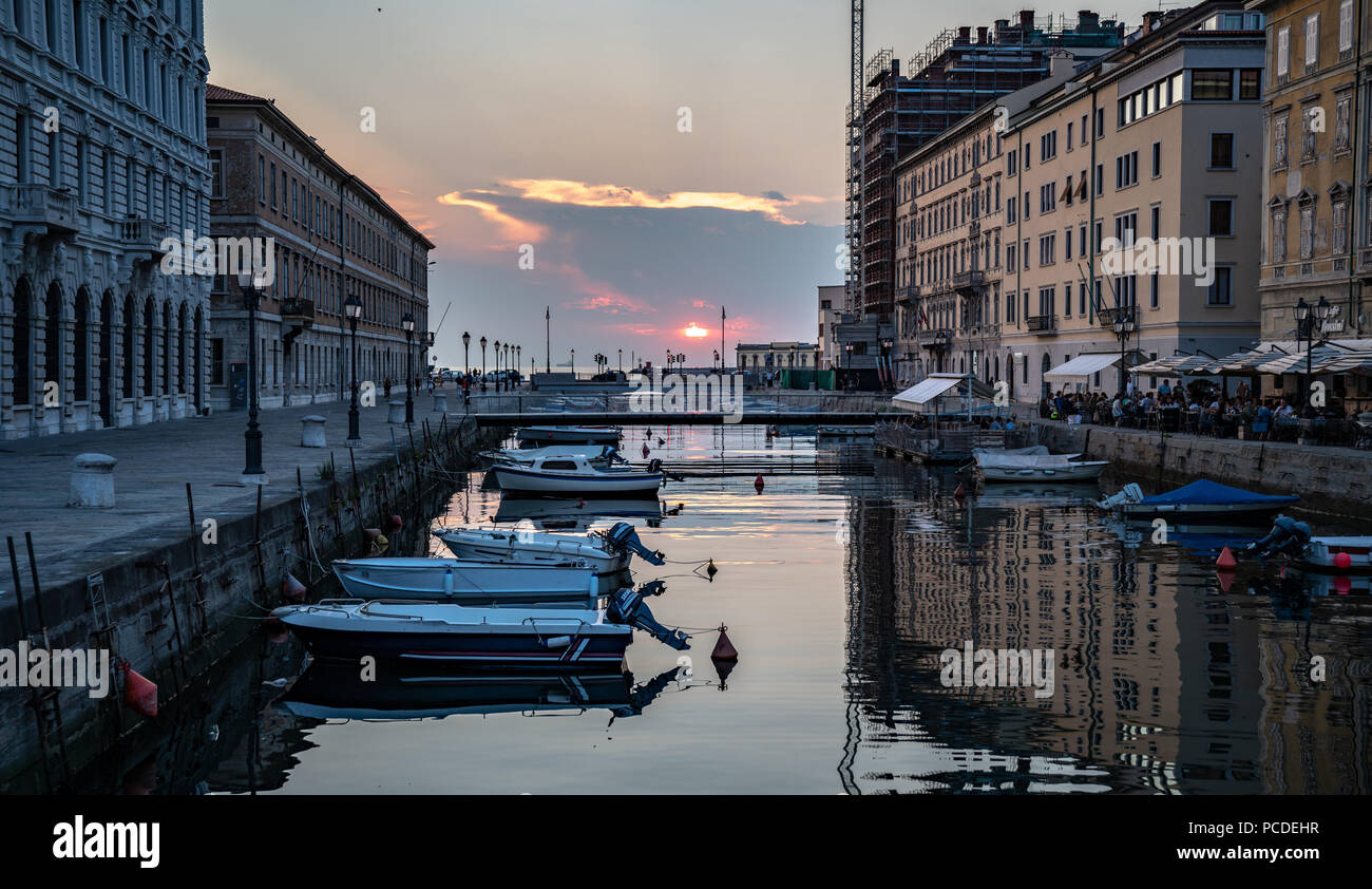 Trieste, 31 luglio 2018. Il sole tramonta sul mare Adriatico come si vede dal Canal Grande nel centro di Trieste. Il canale navigabile, perpendic Foto Stock