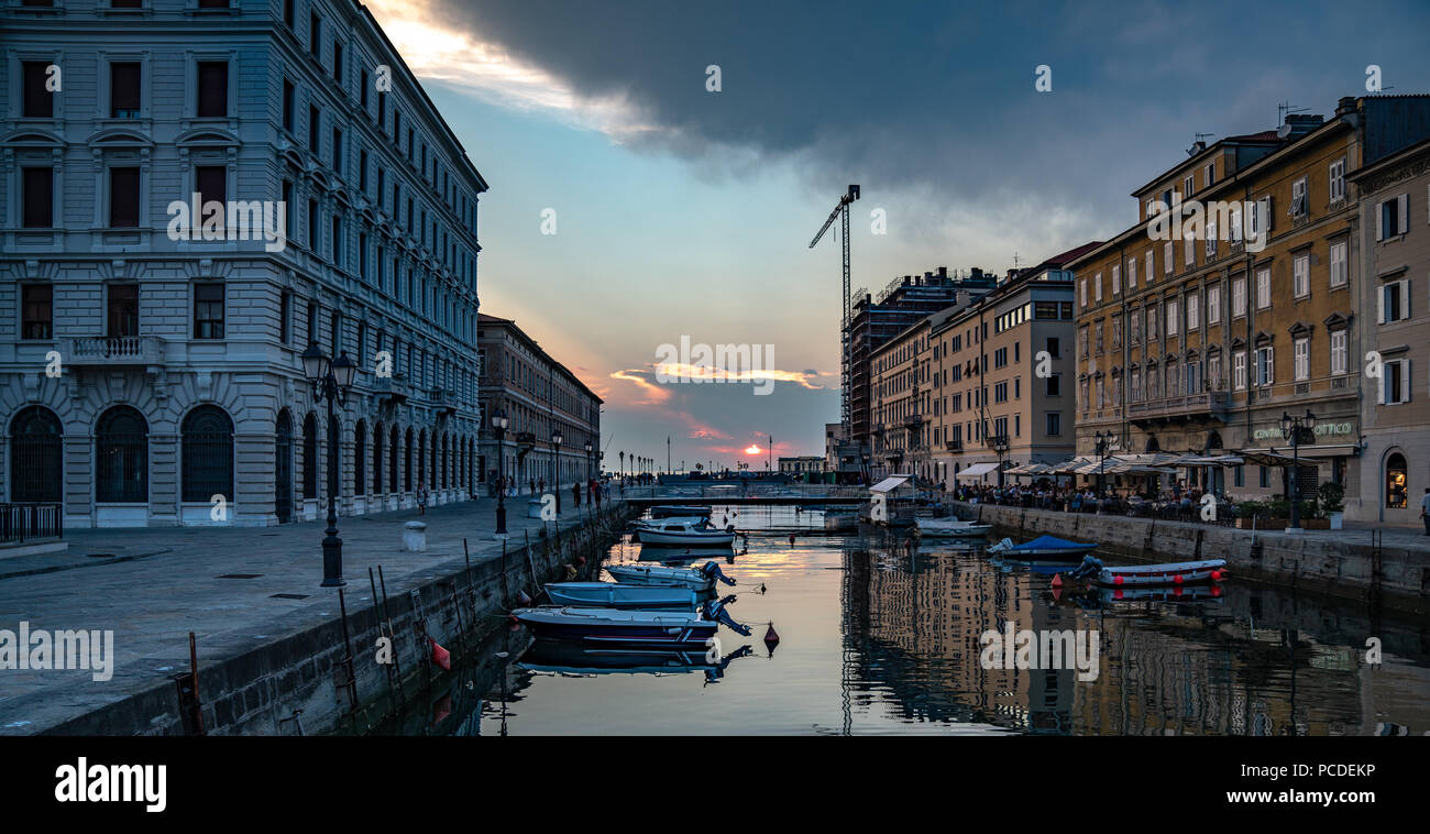Trieste, 31 luglio 2018. Il sole tramonta sul mare Adriatico come si vede dal Canal Grande nel centro di Trieste. Il canale navigabile, perpendic Foto Stock