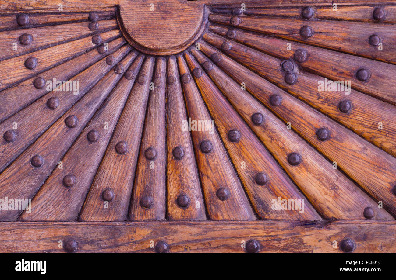 Ornate pattern in legno con rivetti di metallo. In rilievo la parte in legno  della vecchia porta con decorazione geometrica a forma di sole con raggi  Foto stock - Alamy
