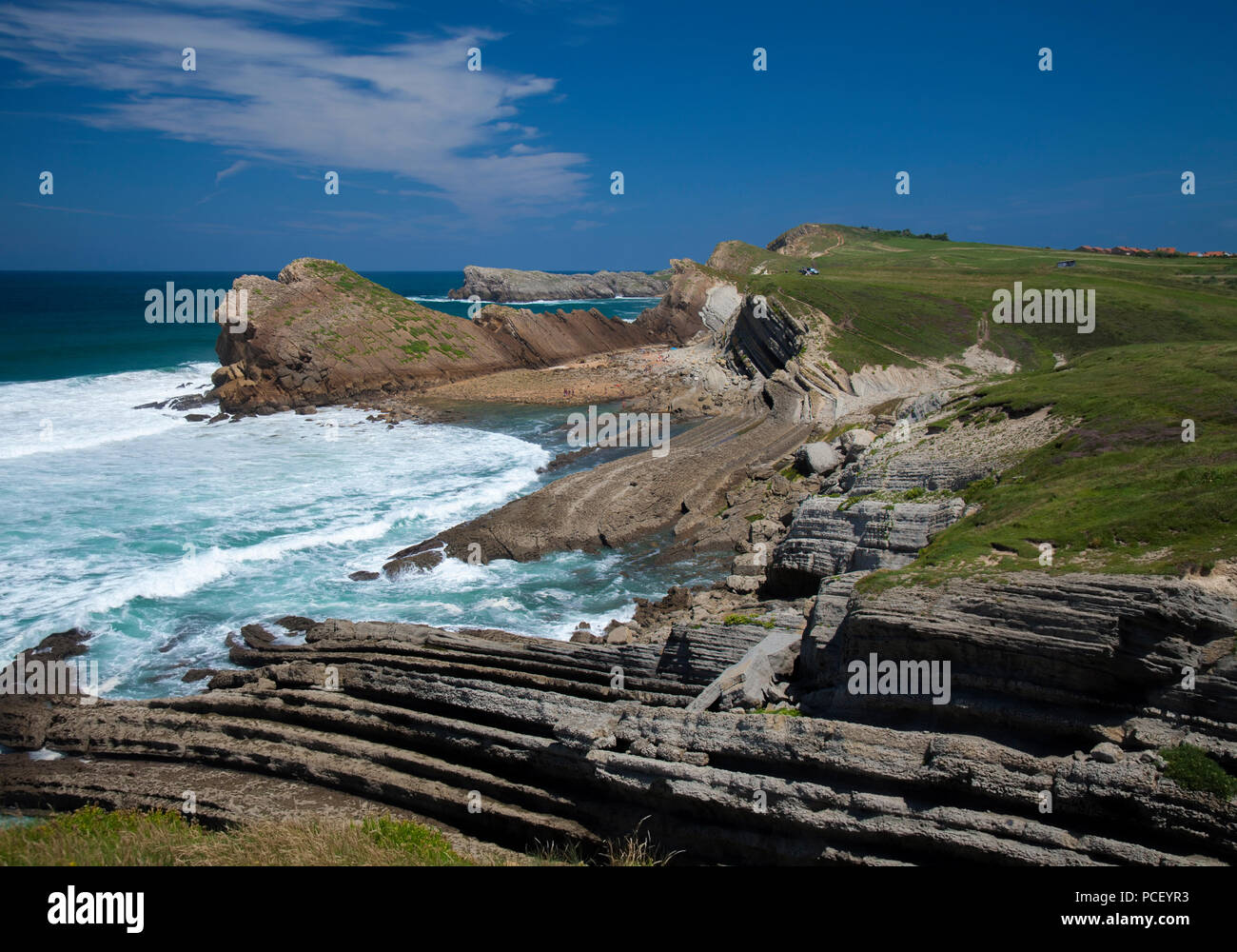 Cantabria, Costa Quebrada attorno a Playa El Madero beach, di onde che si infrangono contro le rocce che proteggono la spiaggia Foto Stock