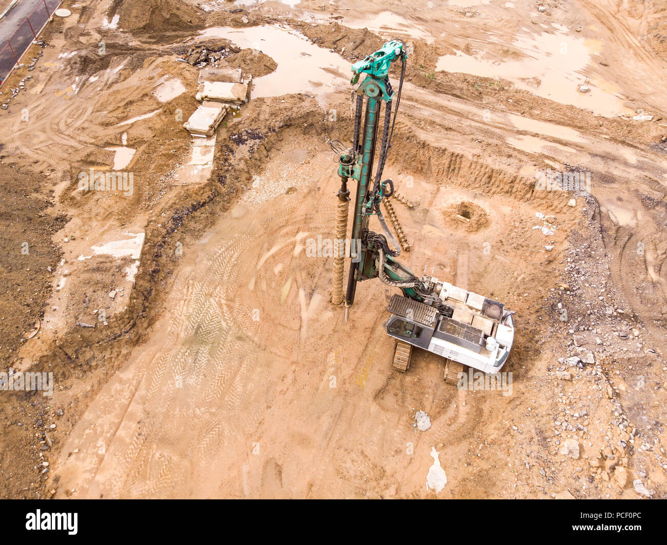 Macchina idraulica per la perforazione di pozzi e installazione di pali al sito in costruzione Foto Stock