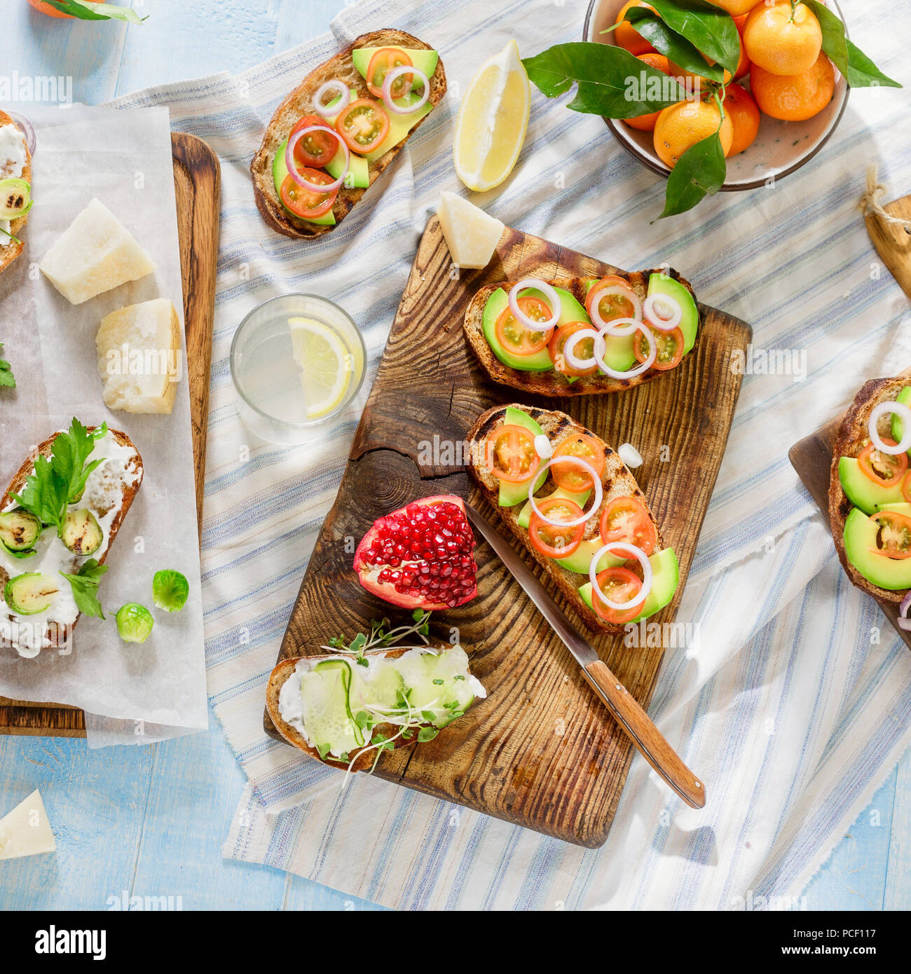 Set di cibo vegetariano blu sul tavolo di legno con limonata fatta in casa. Bruschetta con pomodori, cetrioli, cavolini di Bruxelles e insalata con ceci e Foto Stock