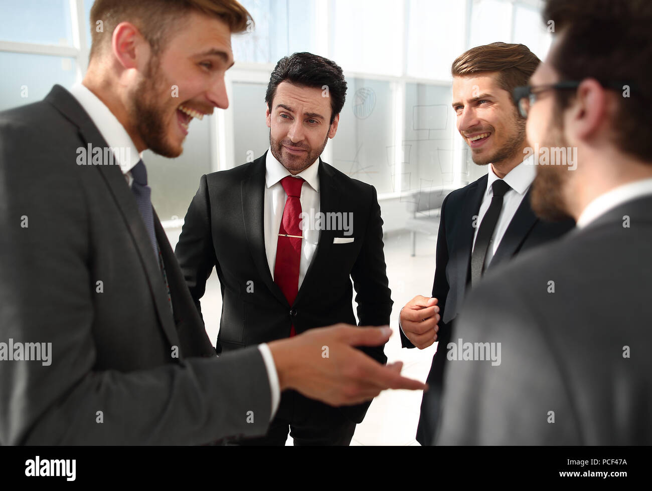 Manager e dipendenti della società parlando in piedi in ufficio Foto Stock