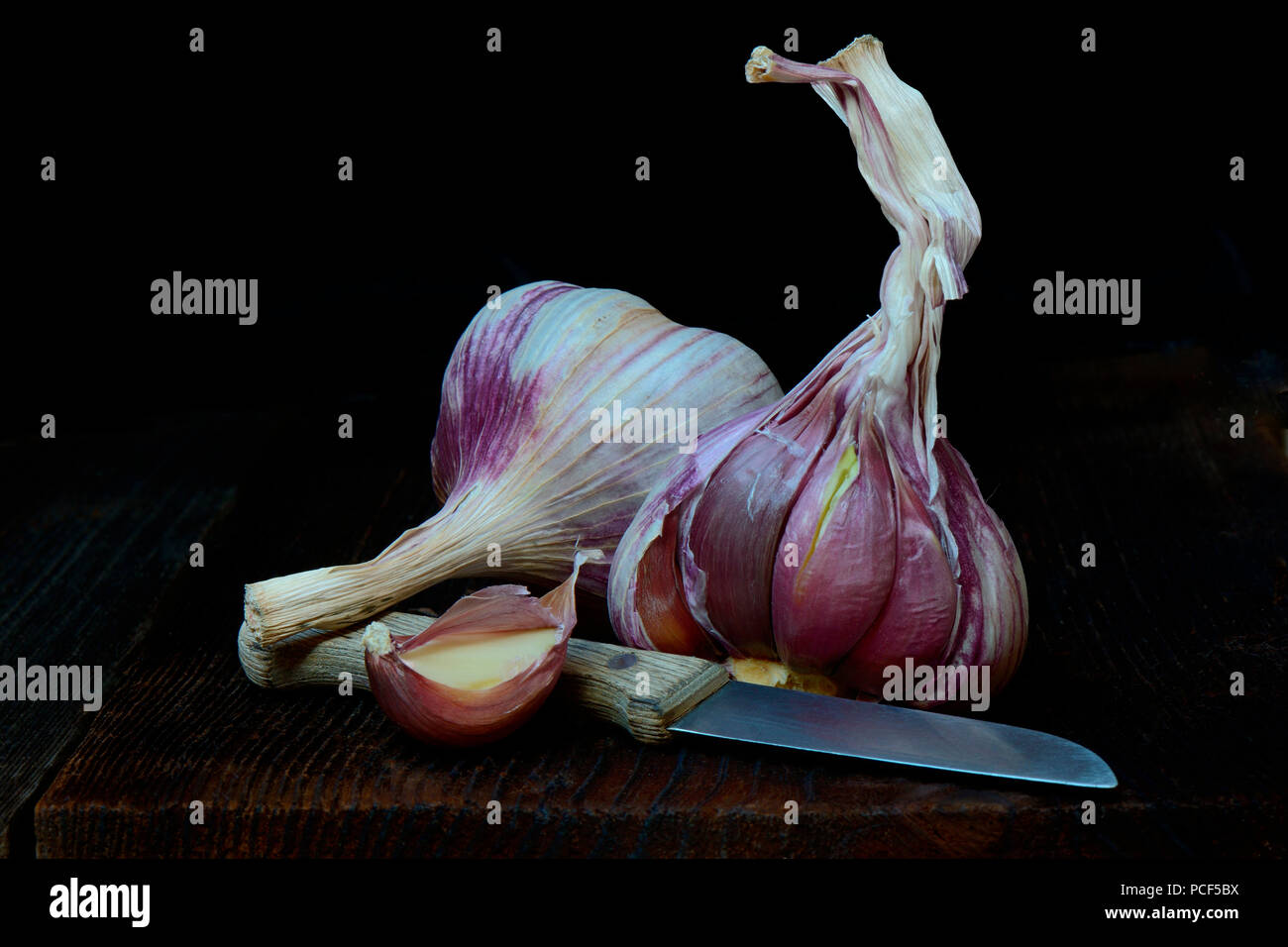 Knoblauchknollen und Messer, Allium sativum Foto Stock