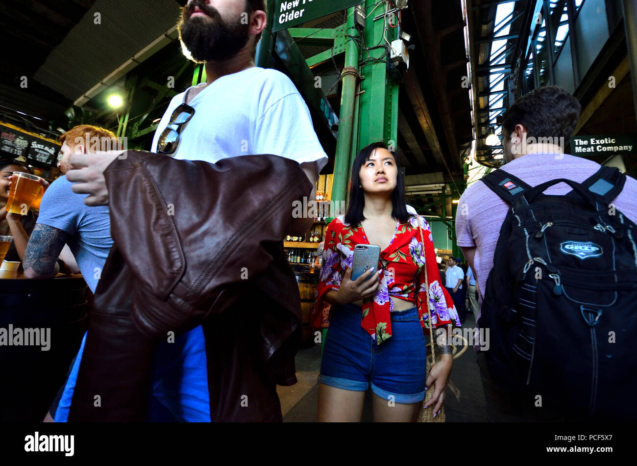 Turisti asiatici in un affollato mercato di Borough, Southwark, Londra, Inghilterra, Regno Unito. Foto Stock