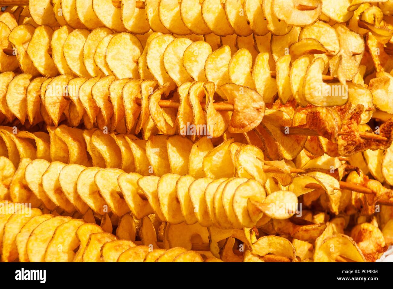 Spirale di patate fritte, su bastoni di legno a spirale. La vendita di  prodotti alimentari al