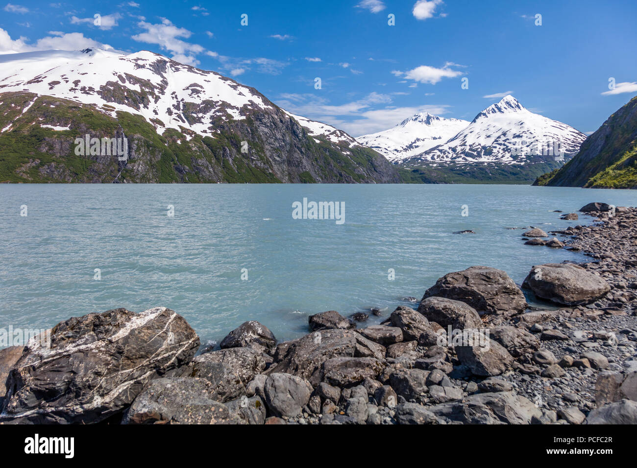 Montagne innevate intorno al lago di Portage che è un lago glaciale in Chugach National Forest sulla Penisola di Kenai dell Alaska Foto Stock