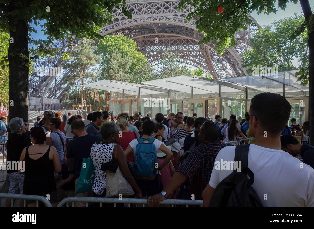 Parigi, Francia. 2 agosto 2018 - Parigi, Francia: turisti coda fuori l'ingresso della Torre Eiffel dopo una unione per Tour Eiffel dipendenti chiamato per uno sciopero. Tour Eiffel i lavoratori si lamentano del fatto che essi hanno a che fare con lunghi ritardi e arrabbiare i turisti a causa di un nuovo muro di sicurezza essendo eretto intorno al famoso monumento. Credito: Fotografia Idealink/Alamy Live News Foto Stock