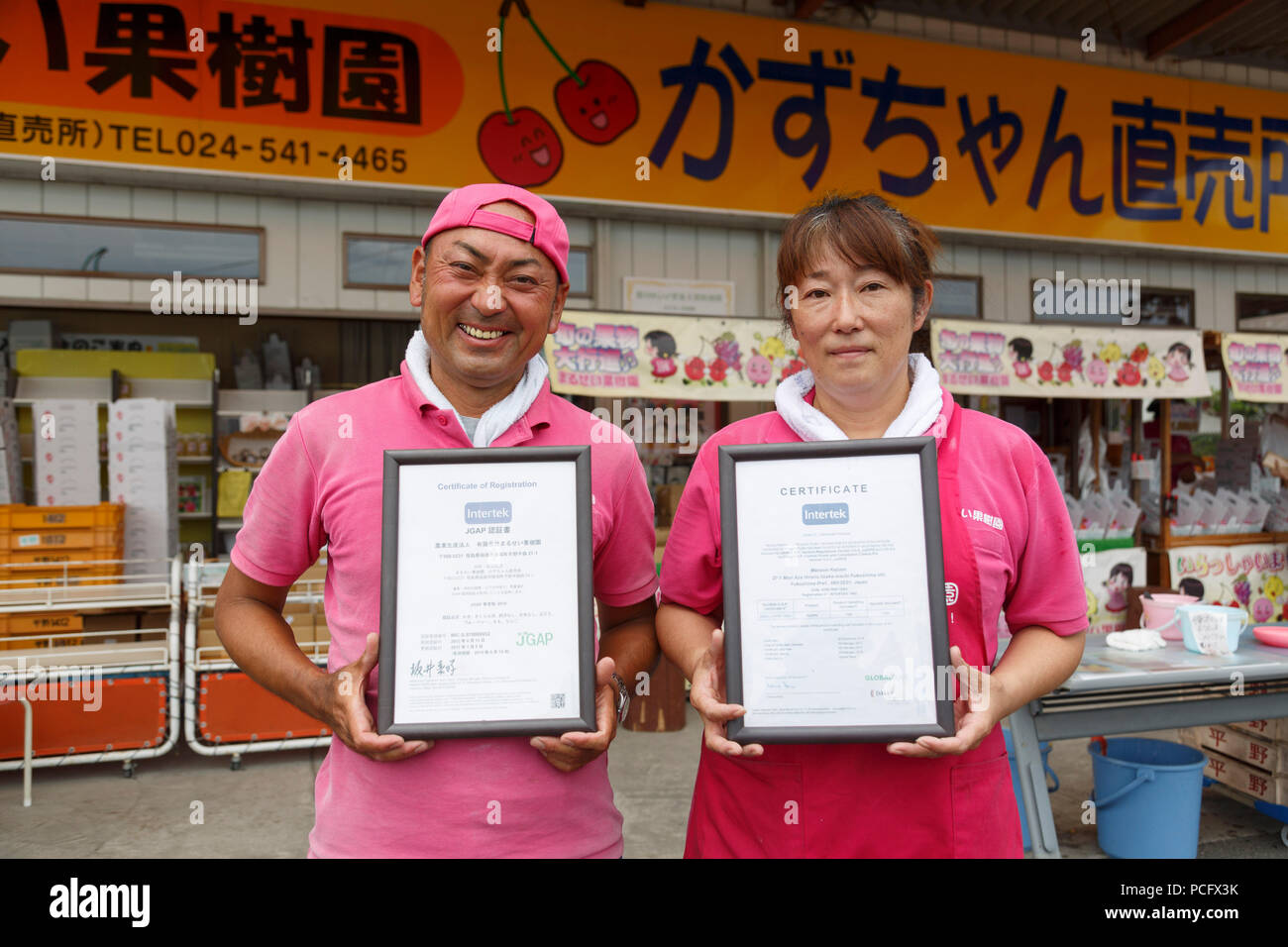 Seiichi Sato (L) presidente della frutta Marusei fattoria accanto alla moglie, mostra il JGAP (Giappone buone pratiche agricole) e Global GAP (buona pratica agricola) certificati della loro azienda frutticola Marusei Frutticolo durante il ''1000km staffetta a Tokyo 2018'' Promozione evento a Fukushima il 2 agosto, 2018, Giappone. L'evento annuale organizzato dal Governo Metropolitano di Tokyo, il Tokyo Associazione Sportiva e Tokyo Athletic Association vetrine i tentativi di recupero nel Tohoku area interessata dal 2011 Grande Oriente giappone terremoto. Il 15-giorno relè dalla Prefettura di Aomori a Tokyo è suddiviso in breve 1-2 Foto Stock