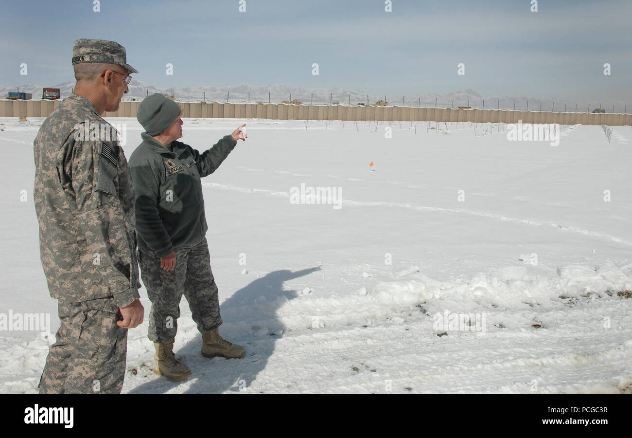Team di Ricostruzione Provinciale Ghazni Delegato Tenente Comandante Becky Blackadar accompagnatrici Navy comando centrale in avanti Comandante, Capitano Glen Anderson in avanti attraverso una base operativa Ghazni 'Green Acres' giardino sperimentale. Sebbene attualmente dormienti, Hardy varietà di mele e uva sono in corso di valutazione da parte del PRT di sviluppo agro-alimentare Team per l'integrazione in provincia di Ghazni's lottando comunità agricole. Come con tutti i marina Augmentees individuali, Blackadar ha ricevuto l'elaborazione in entrata attraverso NAVCENTFWD in Bagram prima di arrivare alla fase FOB. Foto Stock