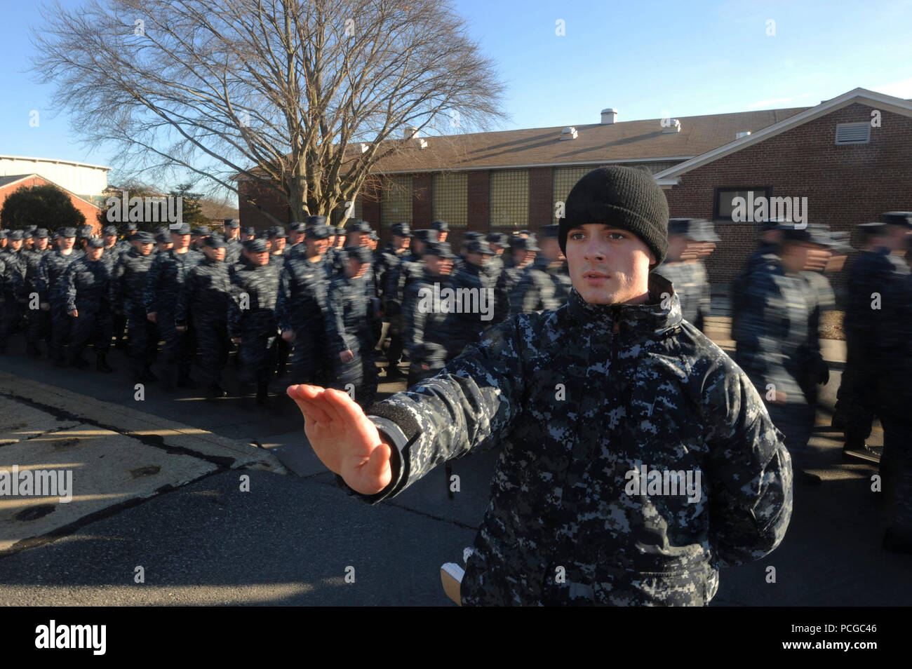 Un marinaio agisce come una protezione su strada come gli studenti marzo a loro settimanale generale formazione militare presso la base di sottomarini arruolato Scuola Navale presso la base di sottomarini di New London, Conn. Foto Stock