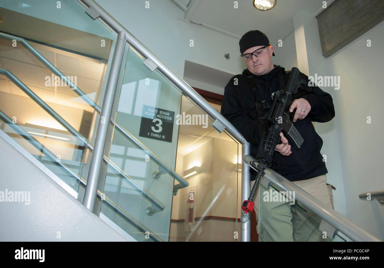 EVERETT, Washington. (Feb. 5, 2015) - Master-at-Arms 1a classe Joshua Johnson, di Shickshinny, Pa., agisce come un tiratore durante un tiratore Attiva drill nella stazione navale di Everett caserma dell'edificio 2027 come parte della protezione annuale esercizio readiness Cortina solido - Cittadella - Protezione (SC-CS15). SC-CS15 usato forza realistica e protezione anti-terrorismo scenari per garantire U.S. Marina militare delle forze di sicurezza a mantenere un elevato livello di disponibilità a rispondere alle mutevoli e minacce dinamiche. Foto Stock