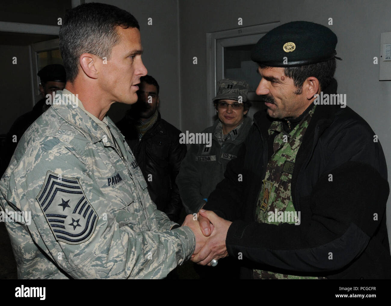 KABUL, Afghanistan - Comando Chief Master Sgt. Richard Parsons, U.S. Forze Aeree centrale, parla a e premi il suo comando moneta per la Afghan Air Force il comando Sgt. Il Mag. Eid Mohammad, durante il suo tour della NATO Training-Afghanistan Aria/438th aria impianti Expeditionary presso la Afghan Air Force Base a Kabul, Afghanistan, Gennaio 19, 2011. Durante la sua visita, Chief Parsons si è incontrato con gli avieri dal 438th Air Expeditionary Wing per far conoscere loro la loro missione. Foto Stock