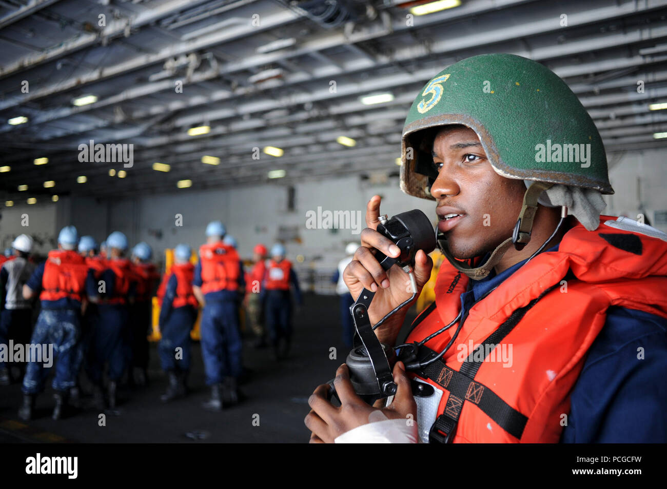 Oceano Pacifico (23 giugno 2013) un marinaio parla in un sound-powered telefono a bordo della portaerei USS George Washington (CVN 73) durante una delle munizioni sul carico. George Washington e la sua aria imbarcato ala, Carrier aria Wing (CVW) 5, fornire un contro-pronto forza che protegge e difende il collettivo di interesse marittimi degli Stati Uniti e dei suoi alleati e partner in Indo-Asia-regione del Pacifico. Foto Stock